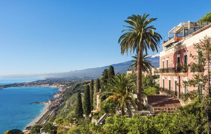 Sunlit Italian coastline with cypress trees and terracotta villas